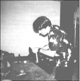 Back in his preferred attire, Hollywood cuts a pumpkin with a chainsaw (!) at Infocom's Halloween party.